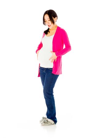 Pregnant adult asian woman isolated on white backgroundの写真素材