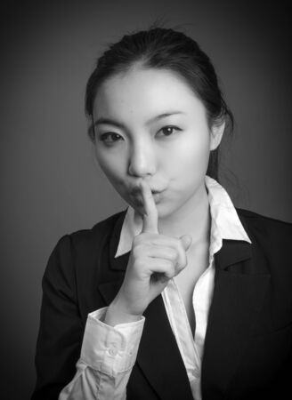 Attractive asian girl in her twenties isolated on a plain background, black and white image shot in a studioの写真素材