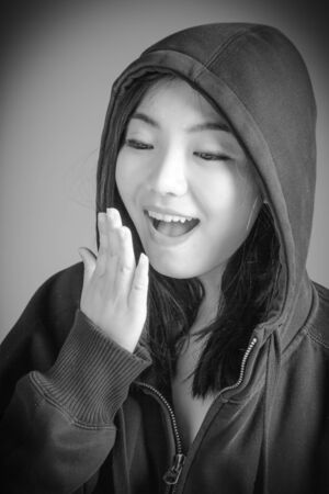 Attractive asian girl in her twenties isolated on a plain background, black and white image shot in a studioの写真素材