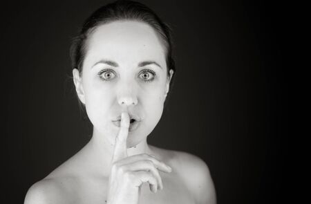 model isolated with finger on lips secretの写真素材
