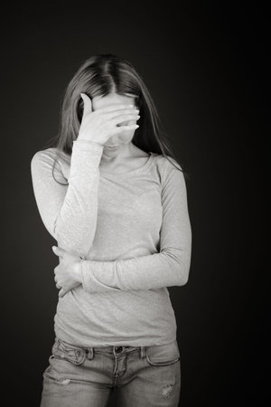 model isolated on plain background ashamed hiding face in hand