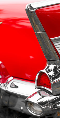 Close-up of tail light of a red shiny classic vintage car