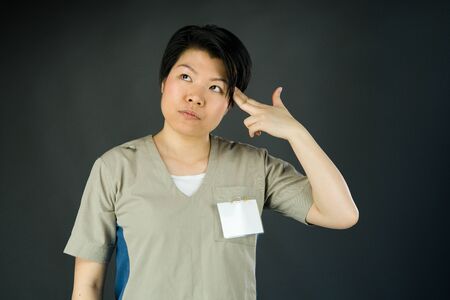 attractive woman on plein background shot in studio with soft lights with an interesting expression and dramatic lightingの写真素材