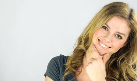 attractive woman on plein background shot in studio with soft lights with an interesting expression and dramatic lightingの写真素材