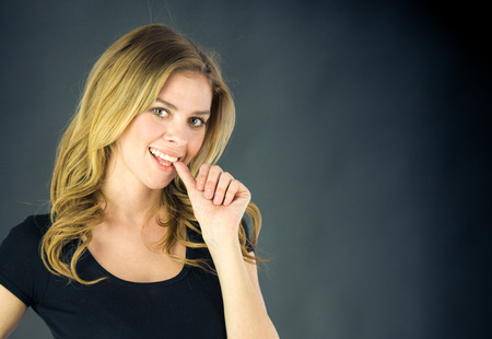 attractive woman on plein background shot in studio with soft lights with an interesting expression and dramatic lightingの写真素材