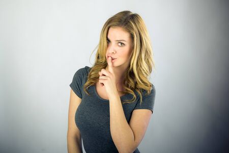 attractive woman on plein background shot in studio with soft lights with an interesting expression and dramatic lightingの写真素材
