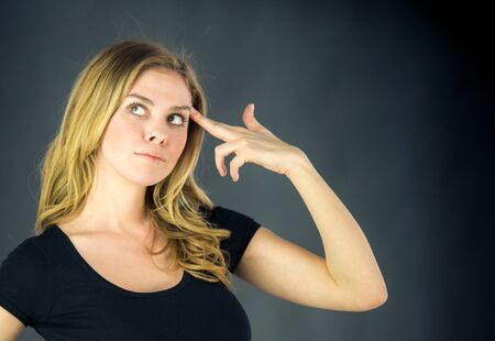 attractive woman on plein background shot in studio with soft lights with an interesting expression and dramatic lightingの写真素材