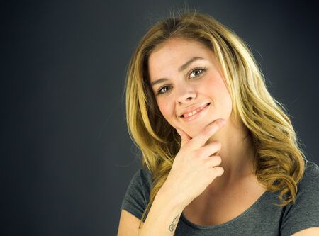attractive woman on plein background shot in studio with soft lights with an interesting expression and dramatic lightingの写真素材