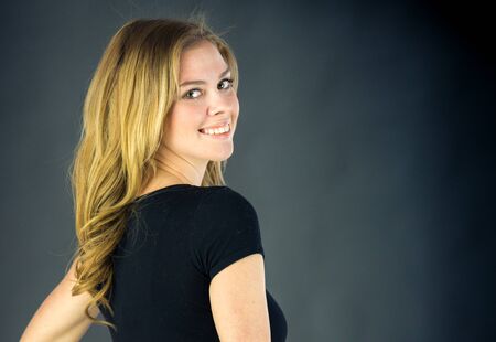 attractive woman on plein background shot in studio with soft lights with an interesting expression and dramatic lightingの写真素材