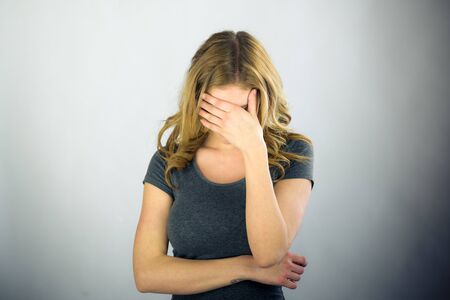 attractive woman on plein background shot in studio with soft lights with an interesting expression and dramatic lightingの写真素材
