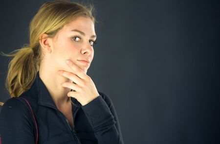 attractive woman on plein background shot in studio with soft lights with an interesting expression and dramatic lightingの写真素材