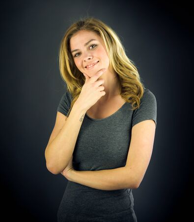 attractive woman on plein background shot in studio with soft lights with an interesting expression and dramatic lightingの写真素材