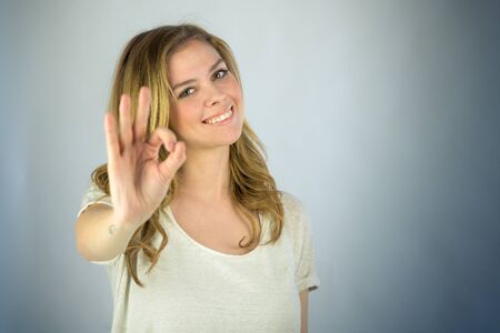 attractive woman on plein background shot in studio with soft lights with an interesting expression and dramatic lightingの写真素材