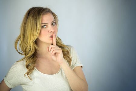 attractive woman on plein background shot in studio with soft lights with an interesting expression and dramatic lightingの写真素材