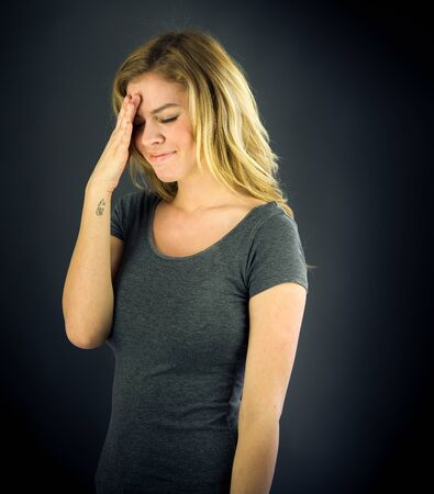 attractive woman on plein background shot in studio with soft lights with an interesting expression and dramatic lightingの写真素材