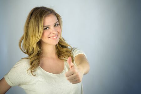 attractive woman on plein background shot in studio with soft lights with an interesting expression and dramatic lightingの写真素材