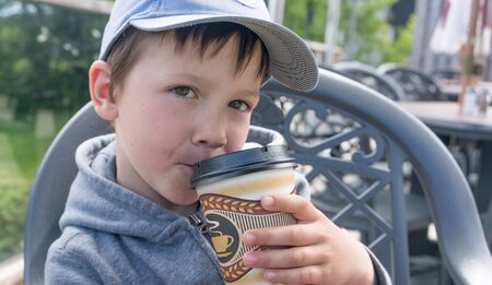 kid boy pretends to drink coffeeの写真素材