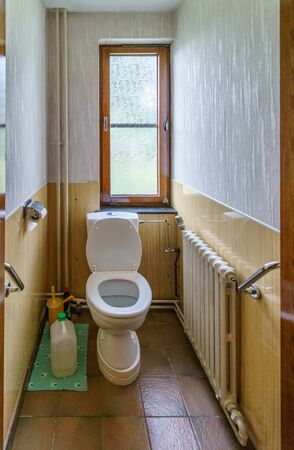 Toilet with seat up in small narrow bathroom with window. belgium europeの写真素材