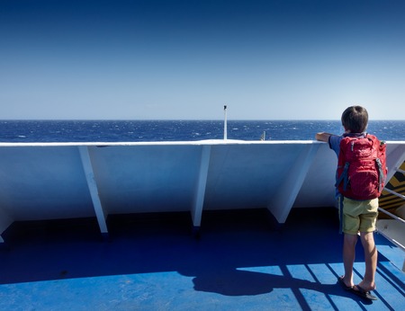 Rear view of boy admiring sea; Paros; Greeceの写真素材