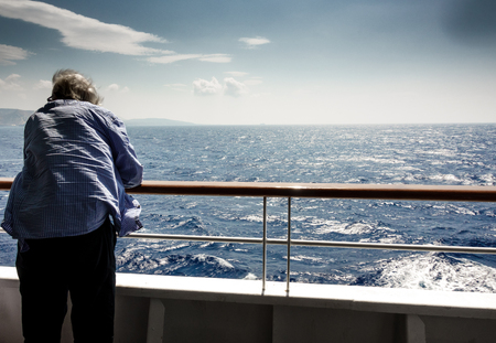 Rear view of senior man looking at view from ship; Paros; Greeceの写真素材