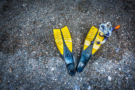 High angle view of snorkel with diving flippers on sand at beach; Crete; Greeceの写真素材