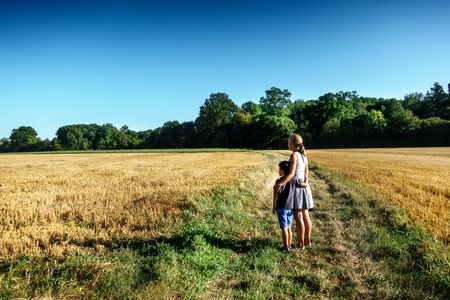 Mother and son standing on path in field; Franceの写真素材