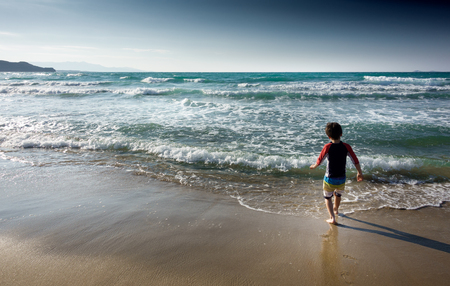 View of a boy walking into the sea Crete Greece Europeの写真素材