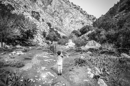 Rear view of boy photographing Church against hill Crete Greeceの写真素材