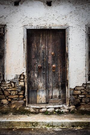 Weathered wooden door with door knob and stone wallの写真素材