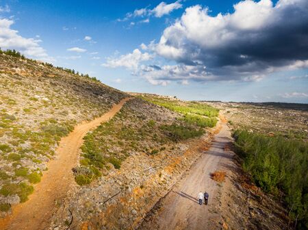 Dirt road amidst agricultural field on mountain landscape, Crete, Greeceの写真素材