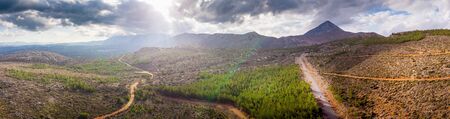 Dirt road amidst agricultural field on mountain landscape, Crete, Greeceの写真素材