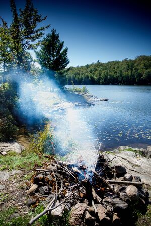 View of campfire at lakeshore, Canadaの写真素材