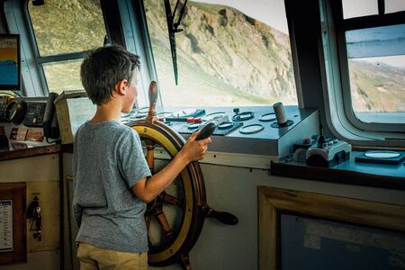 Boy enjoying wheeling the hem of the boat