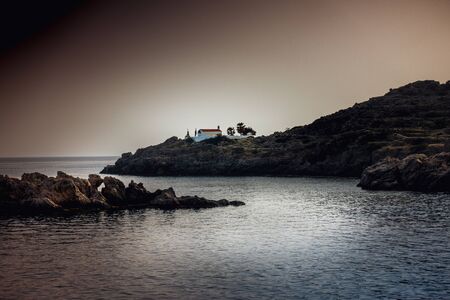View rocky coastline and lighthouse on the cliff at distant