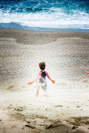 Boy running on beach against sea, Crete, Greece