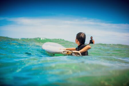 Little boy with surfboard learning surfing in the sea, Greeceの写真素材