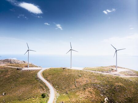 Close-up of windmills and mountain road against sky