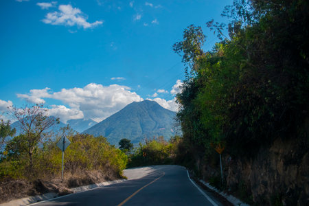 Road in the mountains with a view of the volcano on a sunny dayの写真素材