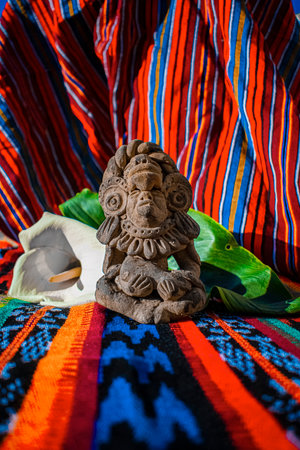Handmade clay statue on a colorful fabric background.の写真素材