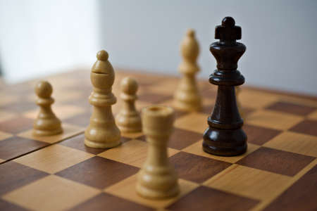 Black chess king surrounded by white pieces.の写真素材