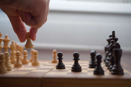 Hand moving a white tower in chess gameの写真素材