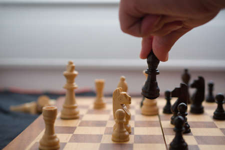 Hand moving a black bishop in chess gameの写真素材