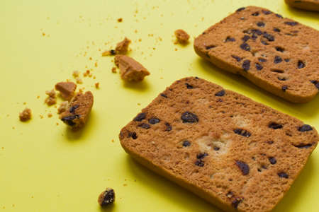 Cookies and some crumbs on a yellow backgroundの写真素材
