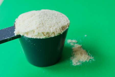 Spoon with white chocolate protein powder. Green backgroundの写真素材