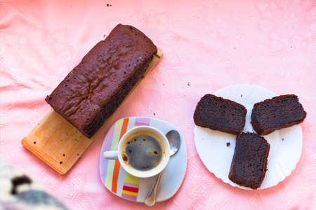 Blueberry cake, coffee and some slices of the cake on a pink backgroundの写真素材