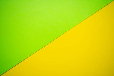 Bright green and bright yellow cardboard background, with a division line from lower left to top rightの写真素材