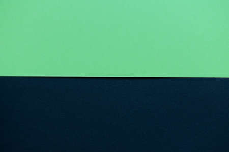 Bright green and black cardboard background, with a horizontal division, green on the top and black on the bottomの写真素材