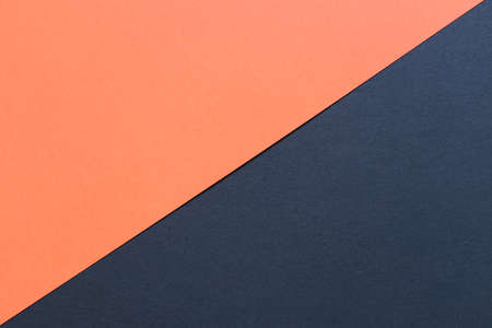 orange and black cardboard background, with a diagonal division, orange on the top and black on the bottomの写真素材
