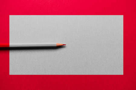 Red pencil over a red background, with a gray rectangle in the middle. The pencil is desaturated in the rectangle, except for its tipの写真素材
