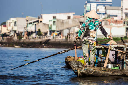 vietnamese woman sailing in can tho river in vietnamの写真素材